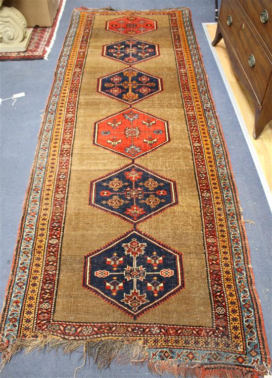 A Caucasian runner, with foliate motif hexagons on a brown ground, multi-bordered, 290 x 98cm